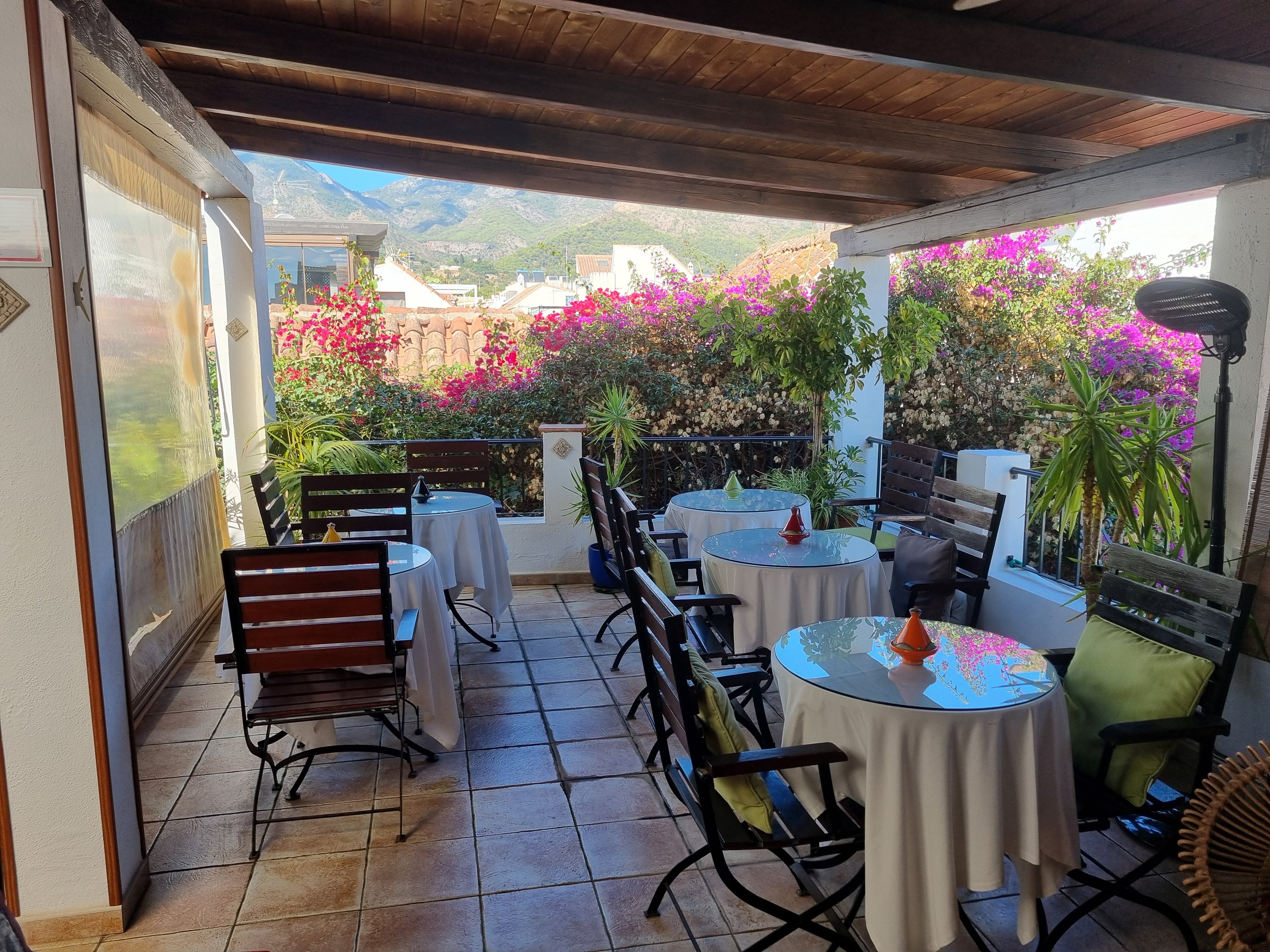 La Villa Marbella facade on Calle Príncipe, with bougainvillea cascading over a wrought-iron balcony and the cobblestone street beyond