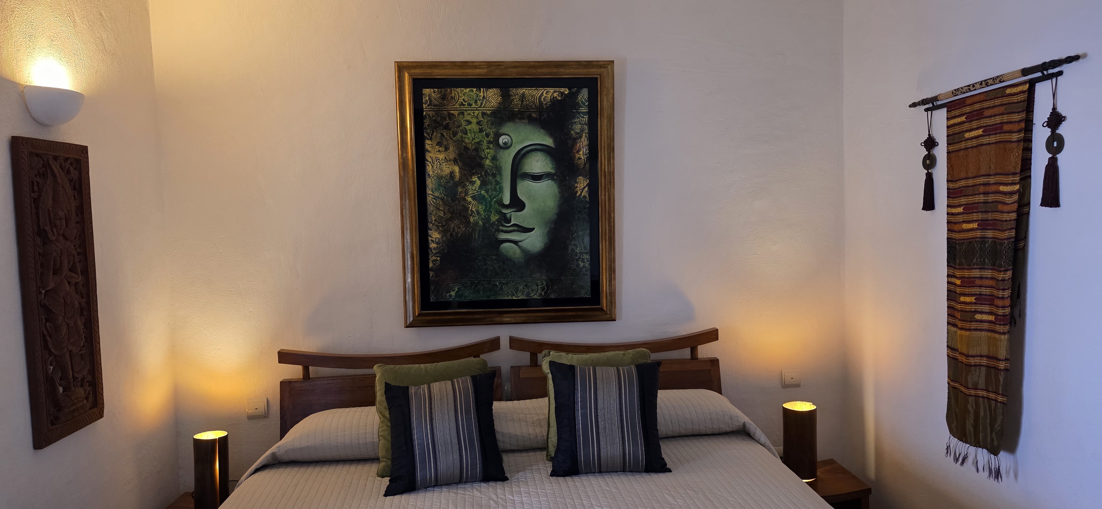 A four-poster bed dressed in cream linen against a slate wall